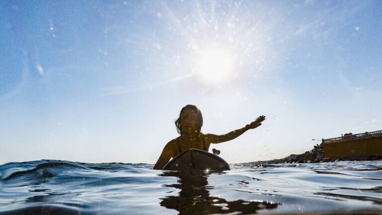 Mulher remando em prancha de surfe