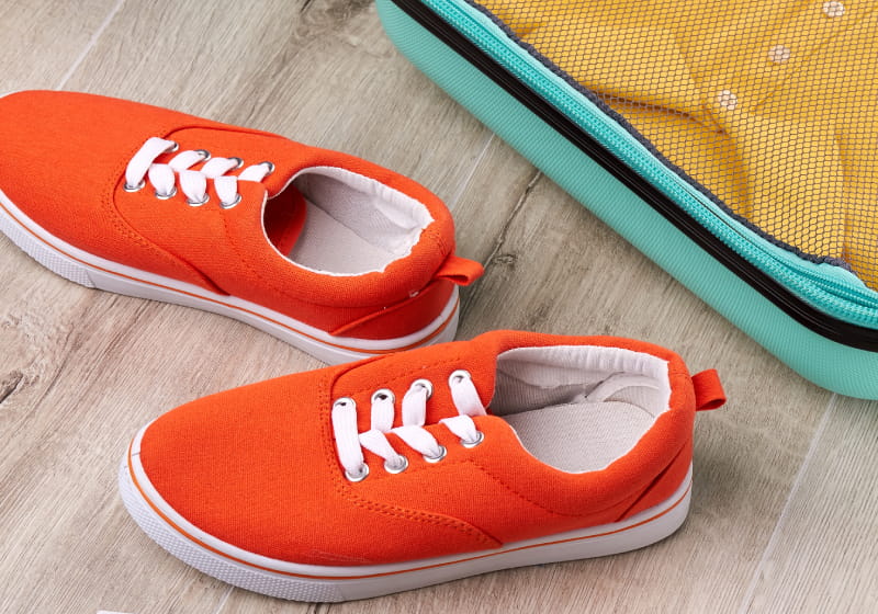 sapato vermelho perto da mala de viajem arrumada 