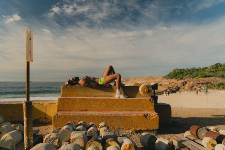 homem deitado na academia do arpoador e praia ao fundo