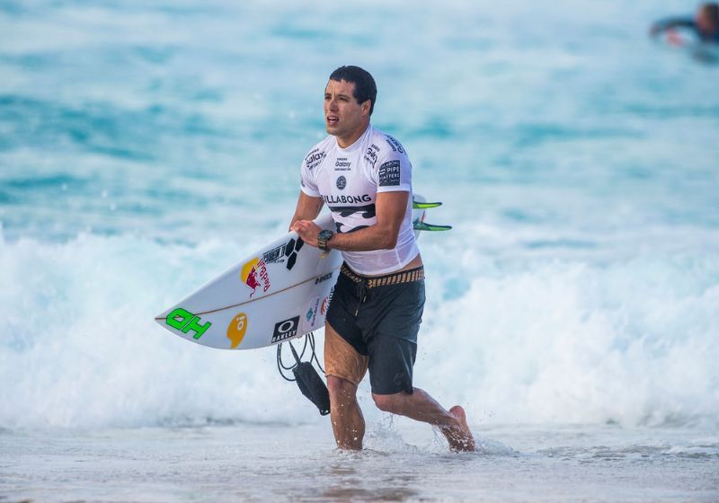 surfista adriano de souza voltando do mar correndo segurando prancha