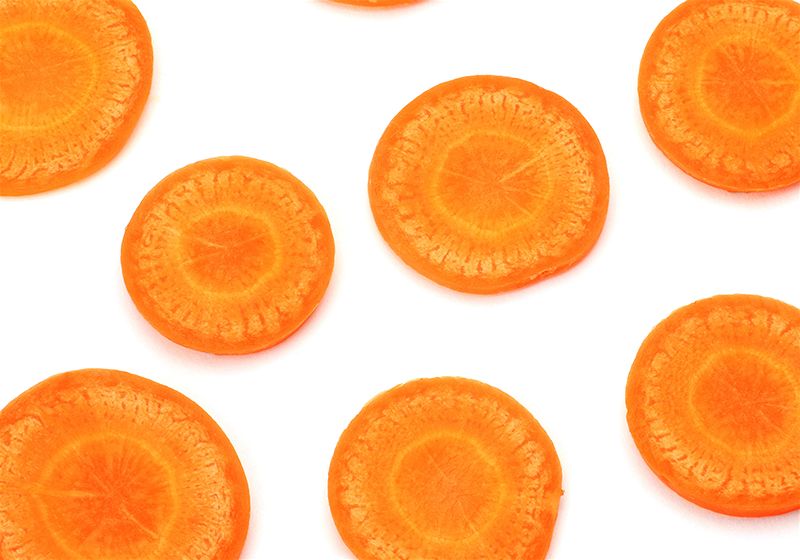 imagem com fundo branco e várias rodelas de cenoura 
