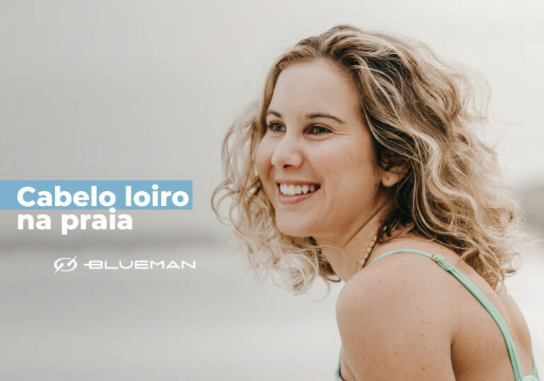 mulher de lado sorrindo com cabelo loiro na praia