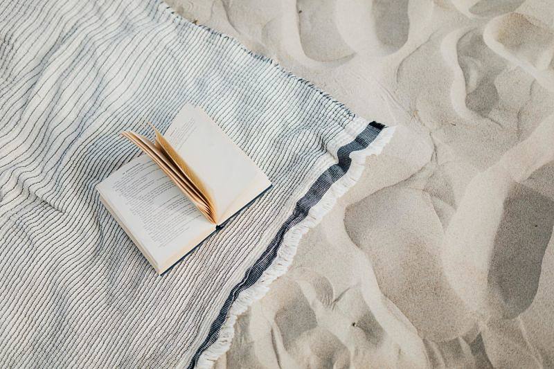 canga com livro na areia