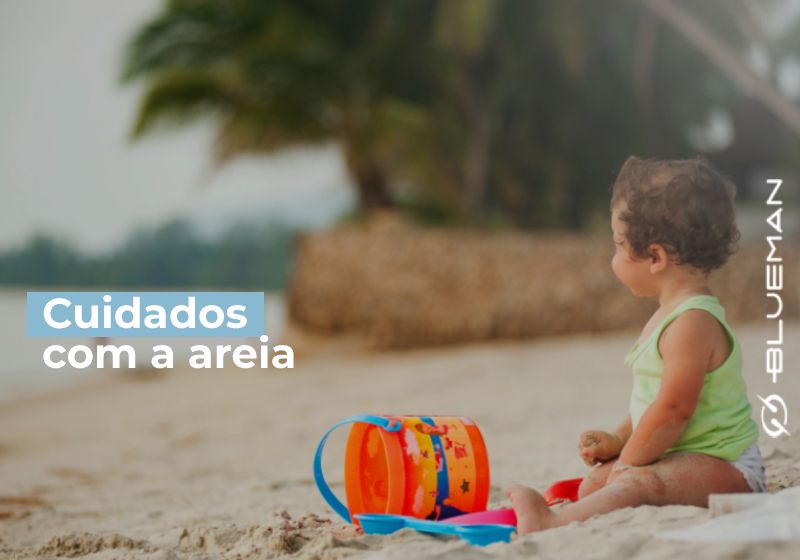 bebe sentado na areia da praia com brinquedinhos