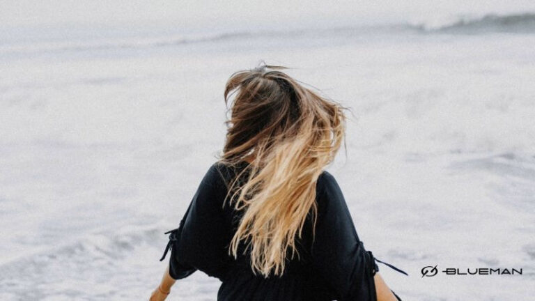 Mulher com cabelos ao vendo em praia