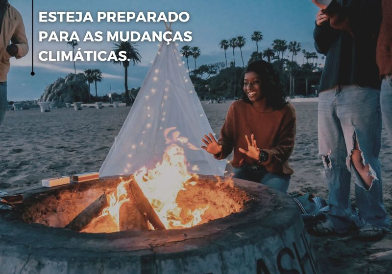 Pessoas ao redor de fogueira feita na praia.