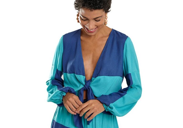 Mulher olhando para baixo vestindo roupa de tecido leve e manga comprida