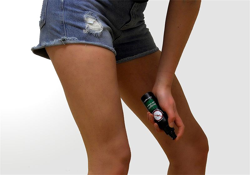 Pessoa passando repelente em suas perna