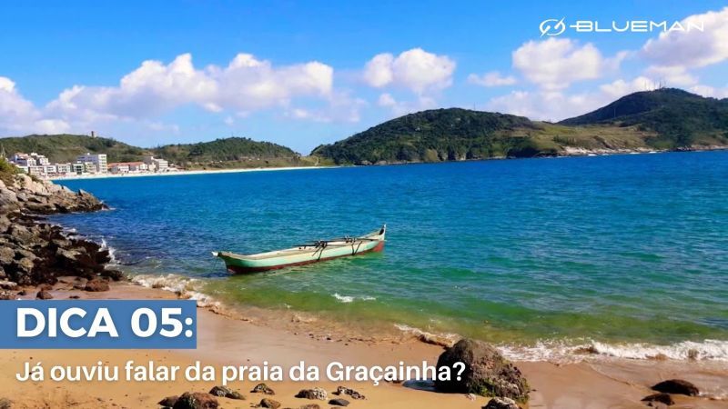 A menor praia da cidade Vista de praia com pequeno barco atracado perto de faixa de areia.