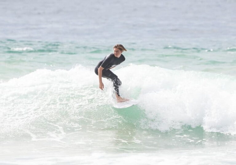 homem em uma onda com uma prancha surfando na praia