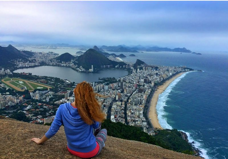 mulher sentada em pedra da trilha dois irmãos