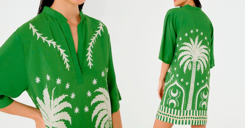 modelo usando um vestido curto, soltinho e estampado de cor verde