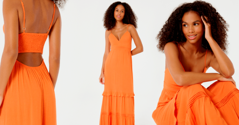 modelo feminina de cabelo cacheado usando um vestido longo laranja com recorte nas costas