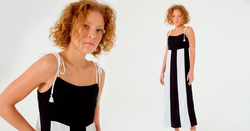 modelo ruiva usando um vestido longo e reto nas cores preto e branco