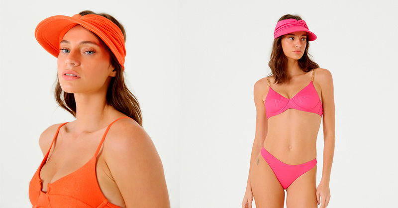 Mulheres vestindo uma viseira na cor laranja e outra na cor rosa